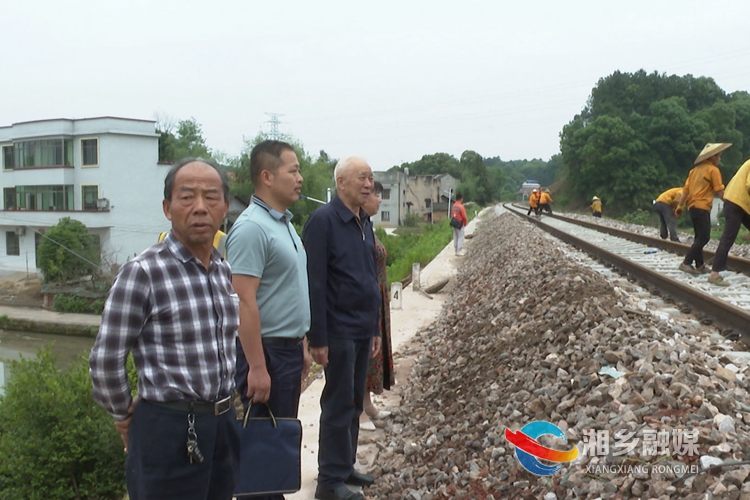 周培与村干部一道实地查看穿村而过的红色旅游铁路专线。.jpg